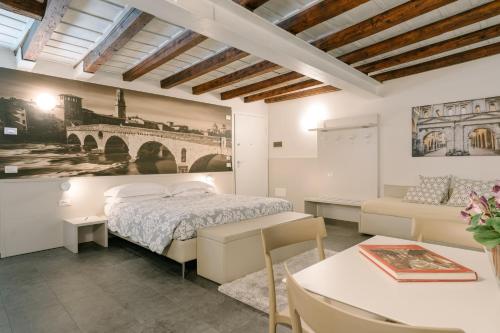 a bedroom with a bed and a couch and a table at Hotel Giulietta e Romeo ***S in Verona