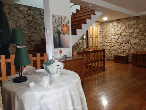 Habitación con mesa y pared de piedra. en casa na aldeia - entre Fundão e Covilhã, en Covilhã
