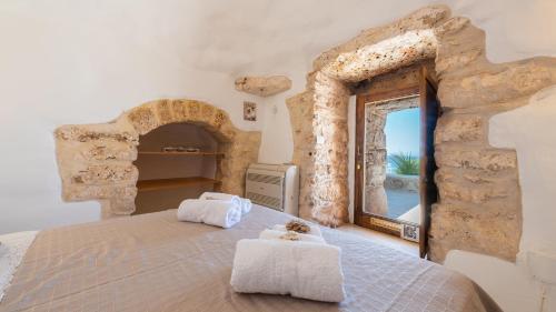 a bedroom with a bed and a large window at Tenuta Scialandre 10, Emma Villas in Patù