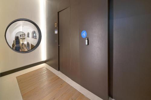 a hallway with a door with a round mirror at Parador de Turismo de León in León