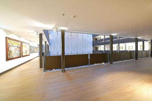 a large room with paintings on the wall and a wooden floor at Parador de Turismo de León in León