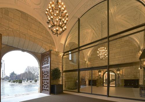 a large building with a chandelier and windows at Parador de Turismo de León in León