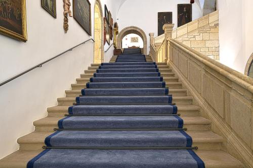 a staircase in a building with blue carpeted steps at Parador de Turismo de León in León