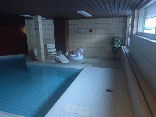 a swimming pool in a building with a pool at Ferienwohnung Parsennblick mit Dachterrasse in Davos