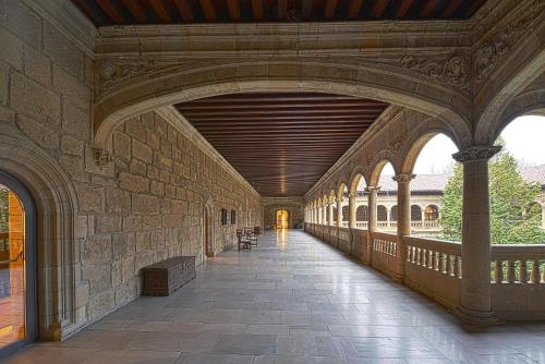 an empty hallway in a building with a stone wall at Parador de Turismo de León in León