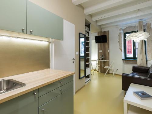uma cozinha e uma sala de estar com um lavatório em Tre Porte Rovinj em Rovinj