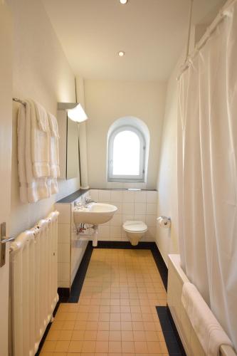 a bathroom with a sink and a toilet and a window at Cosy 2-bedroom near lake - Stardust 31 in Zurich