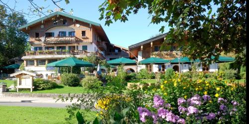 a hotel with a garden in front of a building at Hotel Maier zum Kirschner in Rottach-Egern