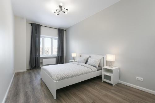 a white bedroom with a bed and a window at GERBERA APARTMENT 3к ЖД Вокзал Аквапарк Центр in Novosibirsk