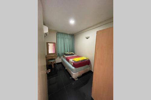 ein kleines Schlafzimmer mit einem Bett und einem Fenster in der Unterkunft PORT DICKSON -GLORY BEACH RESORT “SEAVIEW” UNIT~~ in Port Dickson