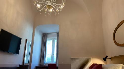 a bedroom with a chandelier and a window at Dimora del Leone Gaeta in Gaeta
