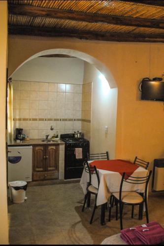 a kitchen with a table and chairs and a kitchen with a stove at Hosteria Las Tinajas in Tilcara
