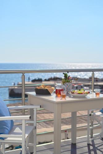 een tafel met eten op het balkon met uitzicht op de oceaan bij FantaSea Luxury Suite in Khóra Sfakíon