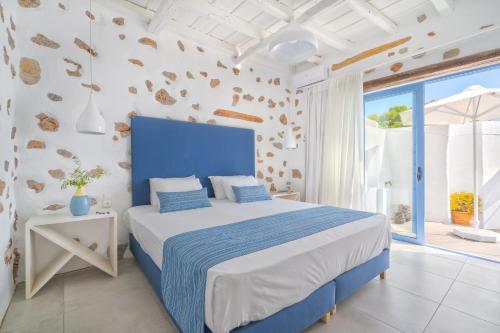 a bedroom with a blue and white bed and a window at FantaSea Luxury Suite in Khóra Sfakíon