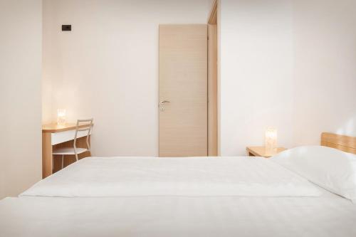 ブレンゾーネにあるCasa Cà Romanaのベッドルーム(白いベッド1台、テーブル付)