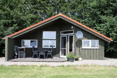 a small cabin with a table and chairs on a deck at Ferienhaeuser Abild - Urlaub auf dem Bauernhof in Tarp