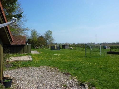 a yard with a basketball hoop in the grass at Ferienhaeuser Abild - Urlaub auf dem Bauernhof in Tarp