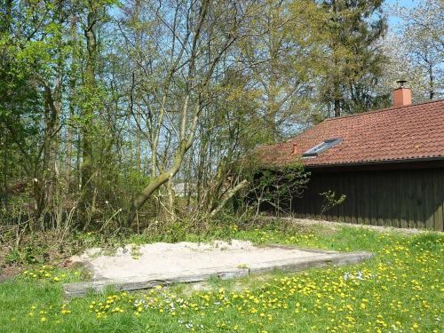 a yard with a house and a fence and flowers at Ferienhaeuser Abild - Urlaub auf dem Bauernhof in Tarp