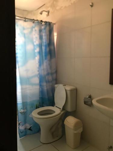 baño con aseo y cortina de ducha azul en Hotel Viru Viru II, en Santa Cruz de la Sierra
