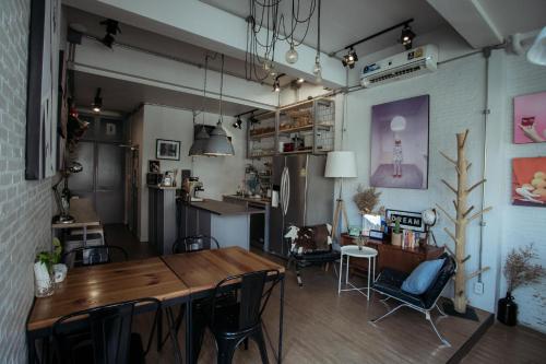 a dining room with a wooden table and chairs at J Poshtel Chiangmai in Chiang Mai