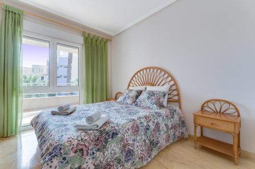a bedroom with a bed and a large window at Apartament PALMERA 100m od morza in Orihuela
