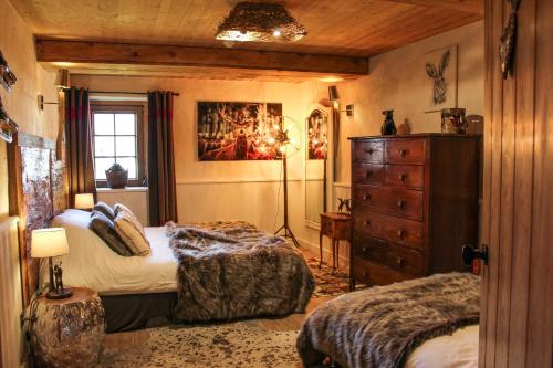 a bedroom with two beds and a dresser at La Ferme du Lac Vert in Montriond