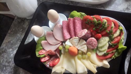 a plate of food with meat and vegetables on a table at Agroturystyka SZYSZKA in Polnica