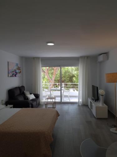 una camera con letto, divano e TV di Apartment near the beach a Marbella