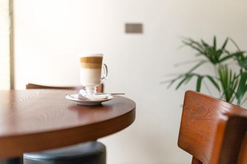 a cup of coffee sitting on top of a wooden table at Kibo Palace Hotel Moshi in Moshi