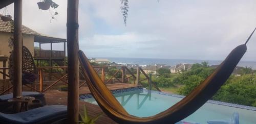 a hammock sitting next to a swimming pool at Chilled Vibes in Ponta Mamoli