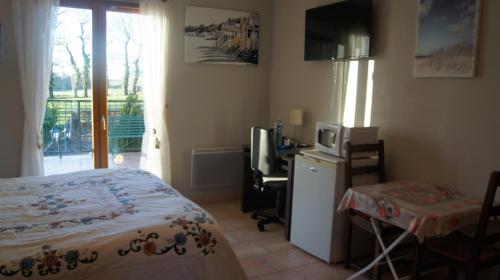 1 dormitorio con 1 cama y escritorio con microondas en Chambres d'Hôtes de Boudeville, en Boudeville