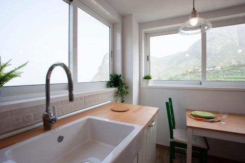 una cocina con un gran fregadero blanco y 2 ventanas en Casa campo y Playa Taganana, en Taganana