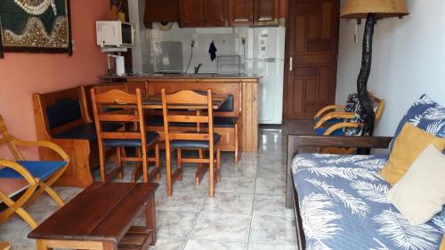 a living room with a table and chairs and a kitchen at Apartamento La balconada in La Paloma