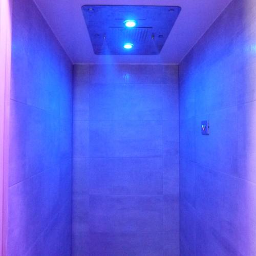 a bathroom with blue and purple lights on the ceiling at Boutique Hotel Bel Sito Wellness & Private SPA in Bardolino