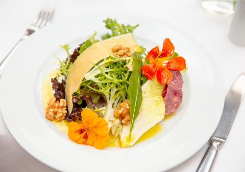 a white plate with a salad on a table at Estanplaza International in Sao Paulo