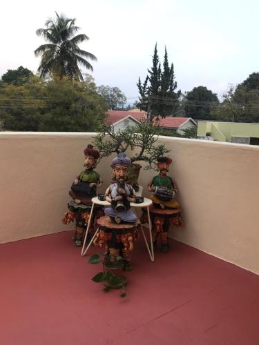 a group of figurines sitting at a table on a balcony at Spencer house in Chikmagalūr