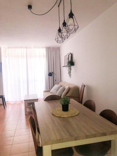 a living room with a wooden table and a couch at peñiscola playa primera linea ,parquing incluido in Peñíscola