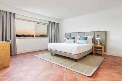 a bedroom with a bed and a large window at The Patio Suite Hotel in Albufeira