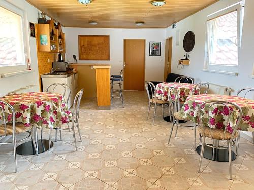 a room with tables and chairs and a kitchen at Apartmaji in sobe Kocjančič in Podčetrtek