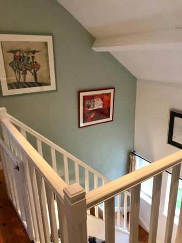 a room with a staircase with two pictures on the wall at Lovely Meadow House in the land of Croix Scaille in Gedinne