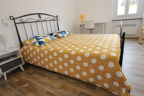T3 proche de la mer في Portel-des-Corbières: غرفة نوم مع سرير مع لحاف برتقالي وبيض
