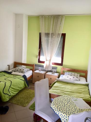 a bedroom with two twin beds and a window at Hostel Lega House in Osijek