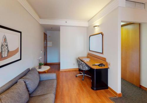 a living room with a couch and a desk at Estanplaza International in Sao Paulo