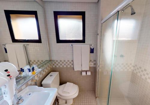 a bathroom with a toilet and a sink and a shower at Estanplaza International in Sao Paulo