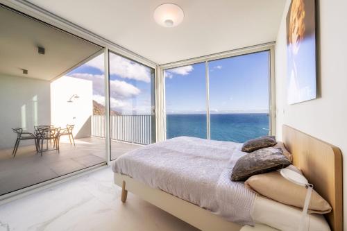 Schlafzimmer mit einem Bett und Meerblick in der Unterkunft Barreirinha Front-Line Sea View I by HR Madeira in Funchal