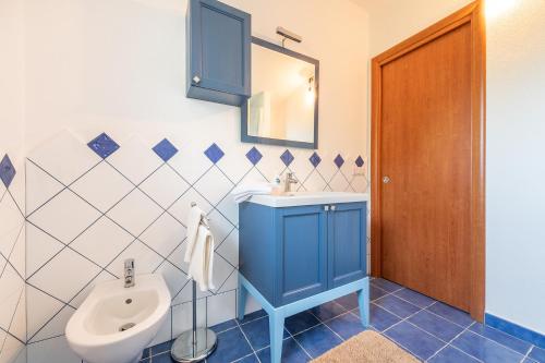 uma casa de banho com um lavatório azul e um WC. em CASE I GINEPRI A/B E ATTICO em Cala Gonone