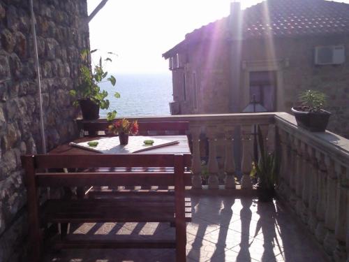 a wooden bench sitting on a balcony with the ocean at Apartments Zuto in Ulcinj