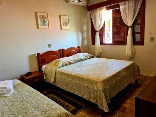 1 dormitorio con 2 camas y ventana en Bartholo Plaza Hotel Santa Catarina, en Penha