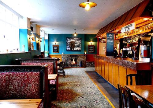 a bar with chairs and a fireplace in a restaurant at The Tors in Okehampton