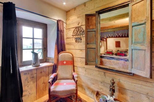 a room with a mirror and a chair and a bedroom at La Ferme du Lac Vert in Montriond